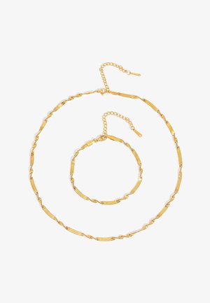 Gold-tone twisted chain necklace and matching bracelet with lobster clasps and extender chains on white background.