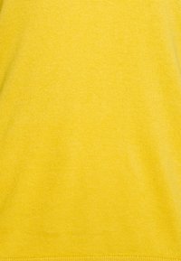 Geel gebreide stof met een gladde textuur, een egale kleur en een eenvoudig ontwerp. Er zijn geen patronen of aanvullende details zichtbaar.