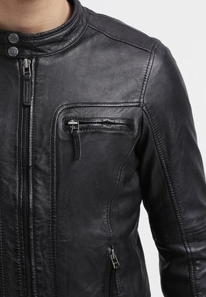 Black leather jacket featuring a high collar, front zip closure, and multiple zippered pockets. Smooth texture with subtle stitching details.