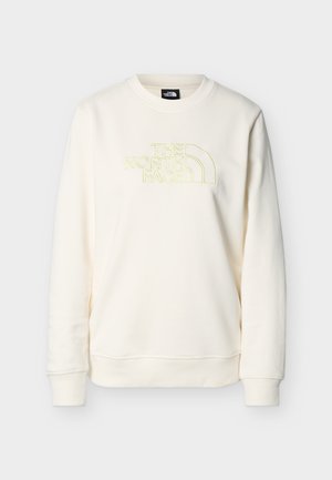 Krēmkrāsas sporta krekls ar apaļu kakla izgriezumu un ribotu aproču un apakšmalu, uz krūtīm gaiši dzeltena izšūta "THE NORTH FACE" logo.