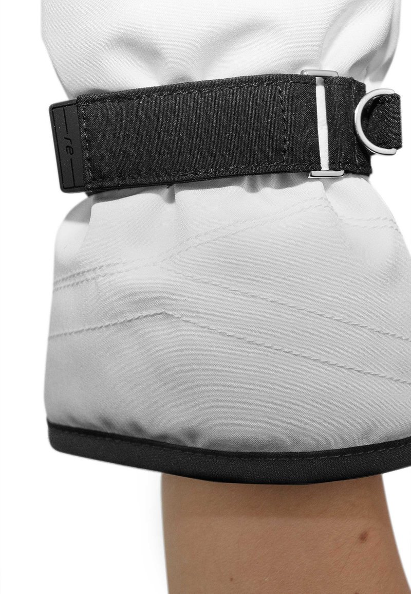 Witte gevoerde handschoen met een zwarte stoffen band en metalen gesp bij de pols. Heeft diagonale stiksels en een zachte, gematteerde afwerking.