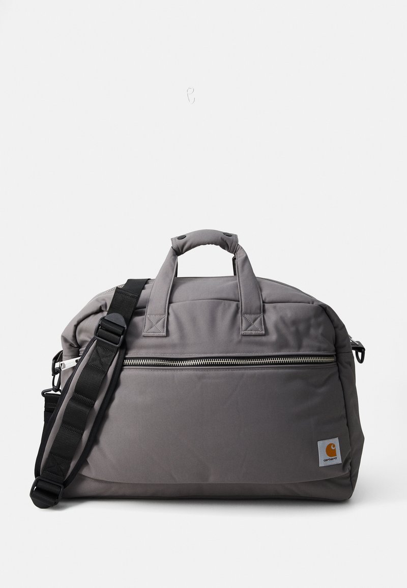 Szürke sporttáska tartós szövetből készült, dupla felső fogantyúval, levehető vállpánttal és elülső cipzáras zsebbel rendelkezik.