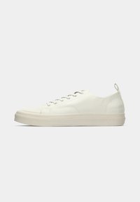 Låg sko i off-white med snörning och texturerad sula, med en dragflik vid hälen mot en neutral bakgrund.