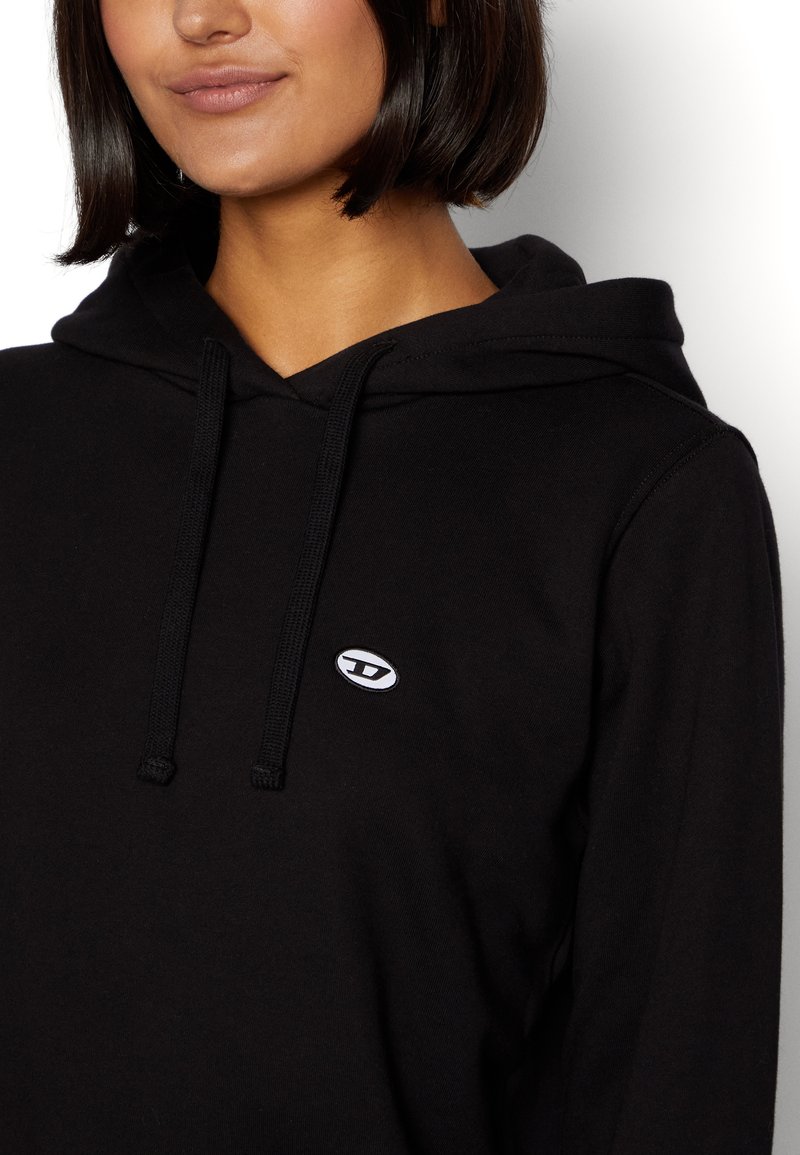 Schwarzer Kapuzenpullover aus weichem Stoff, mit einer Vordertasche und einem gestickten Logo in Weiß auf der linken Brustseite.