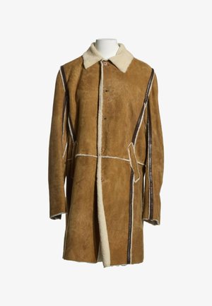 Bruine suède lange jas met crèmekleurige shearling voering, een puntige kraag, knoopsluiting en contrasterende biezen op mouwen en voorkant.