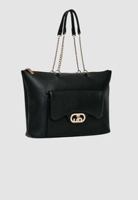 Borsa tote in pelle nera dalla forma strutturata, con una tasca frontale a patta e una chiusura in metallo dorato. Manici corti doppi e dettagli a catena.