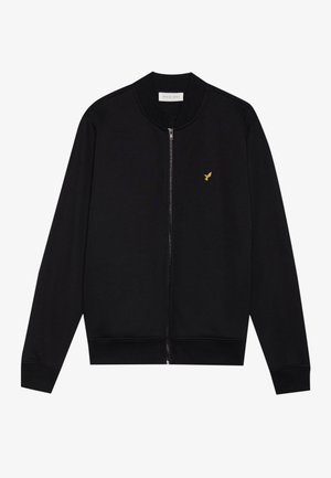 Sudadera negra con cremallera, hecha de tela suave, que presenta un cuello y puños de canalé, con un pequeño logo dorado de un pájaro en el lado izquierdo del pecho.