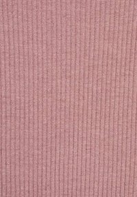 Knitted fabric in soft pink with a vertical ribbed texture. Material appears lightweight and breathable, featuring subtle variations in color.