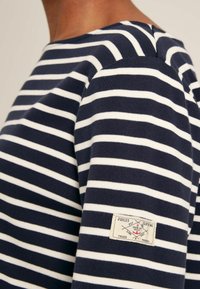 Námořnická a bílá pruhovaná mikina s kulatým výstřihem, texturovaná bavlněná látka a nášivka s logem na levém rukávu.