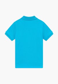 Turkos pikétröja i bomull med klassisk krage, korta ärmar och texturerad tygstruktur. Bakifrån utan prydnader.