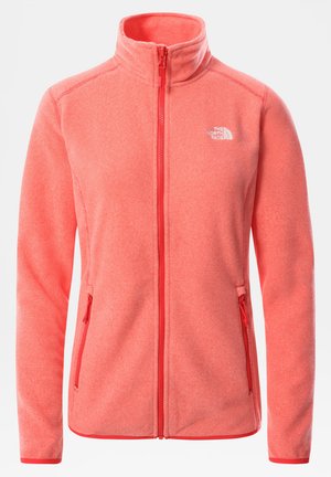 Veste polaire rose corail avec fermeture éclair intégrale, col montant, deux poches latérales zippées et petit logo blanc The North Face sur le côté gauche de la poitrine.