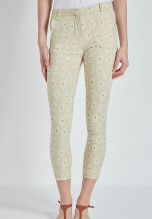 Pantalones cortos de color beige claro con un patrón floral de margaritas blancas. Hechos de algodón, presentan un diseño ajustado y una cintura de altura media.