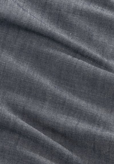 Close-up of dark gray textured fabric with diagonal creases and a subtle weave pattern.