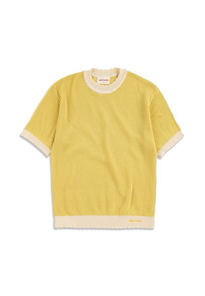 Pull jaune côtelé à manches courtes avec bordures blanches sur les poignets, le col et l'ourlet, avec un petit nom de marque brodé près de l'ourlet inférieur.