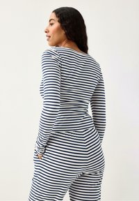 Randigt lounge-set i marinblått och vitt, med långärmad tröja och resår i midjan, i ett mjukt och slätt tyg.