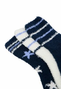 Bløde sokker i navyblå og hvid. Har stjerne- og stribede mønstre. Blød tekstur med en høj, ribbet kant. Velegnet til afslappet brug.