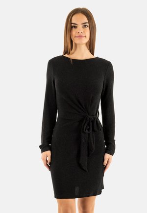 Robe noire à manches longues avec une taille nouée, présentant une texture douce et un tissu légèrement scintillant, tombant juste au-dessus du genou.
