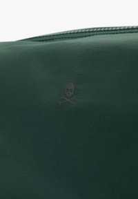 Bolsa de tela verde oscuro con un sutil diseño de calaveras y tibias en negro, con una textura suave y un cierre de cremallera en la parte superior.
