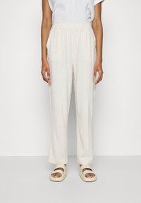 Ljust beige linnesbyxor med elastisk midja, rak bendesign, platta framfickor och en mjuk, strukturerad yta.