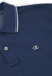 Granatowa koszulka polo z teksturowanej tkaniny, z kontrastowym białym kołnierzykiem i zapięciem na dwa guziki, oraz małym haftowanym logo na piersi.