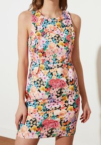 Blomstrede bodycon-kjole med udenærmede ærmer. Har levende pink, blå og gule blomster på en sort baggrund. Glat stoftekstur.