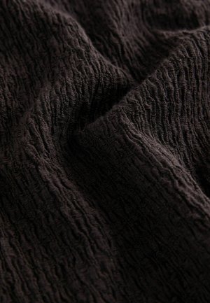 Black textured fabric with a rippled surface pattern, showcasing a soft, slightly crinkled appearance and rich, deep color.