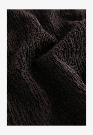 Czarna tkanina o teksturze z falistym wzorem, prezentująca miękki, lekko pomarszczony wygląd oraz bogaty, głęboki kolor.