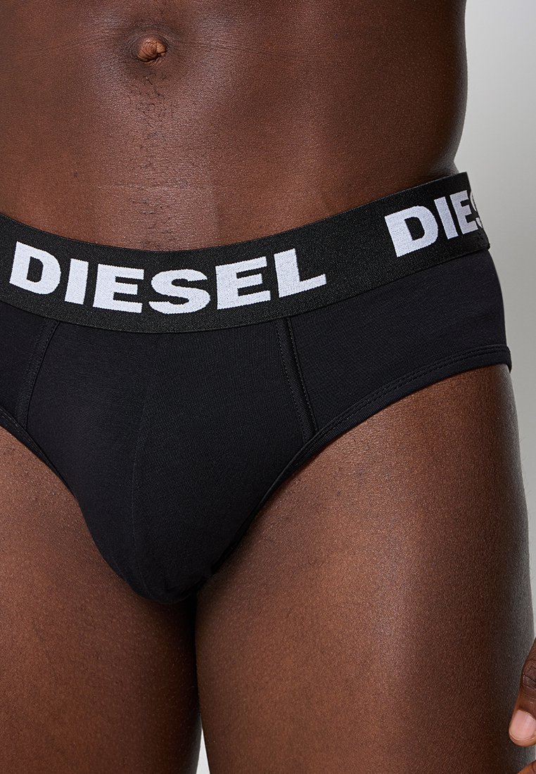 Slip in cotone nero con una ampia vita elastica con logo "DIESEL" bianco. Texture liscia e design aderente per il massimo comfort.