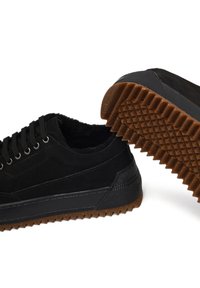 Baskets en nubuck noir avec une semelle en caoutchouc noir texturée, présentant un motif en chevron, des lacets plats et des œillets renforcés.