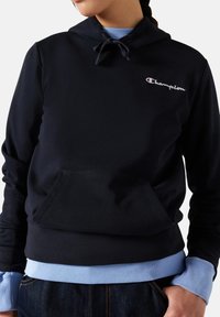 Marineblaue Kapuzen sweatshirt aus Baumwollmischung mit einer vorderen Tasche, Kordelzugkapuze und hellblauen Rippenbündchen und Saum. Mit besticktem "Champion"-Logo.