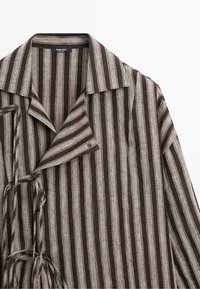 Chemise à manches longues rayée marron et beige avec col et fermetures latérales à nouer, réalisée dans un tissu texturé par Massimo Dutti.