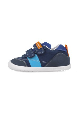 Zapatillas para niños en color marino y azul con tiras de Velcro, suela de goma blanca, costuras de contraste y etiqueta naranja. Parte superior de tela ligera.