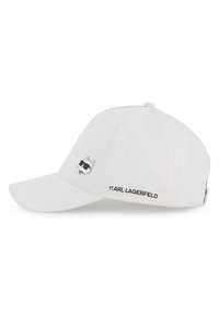 Λευκό καπέλο από ύφασμα με ανάγλυφο μαύρο λογότυπο γάτας με γυαλιά ηλίου. Μια μαύρη ετικέτα "KARL LAGERFELD" βρίσκεται στην πλευρά.