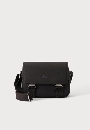 Zwarte rechthoekige crossbodytas met klep, verstelbare band en klein krokodillenlogo aan de voorkant.