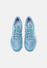 Chaussures de sport bleu clair avec tissu en maille et semelles en caoutchouc. Présentent des accents verts et un design à lacets. Détails blancs subtils sur les côtés.