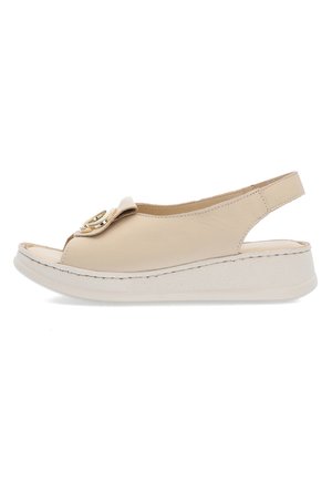 Beżowa sandałka typu slingback z otwartym noskiem, niską koturną i ozdobną, złotą klamrą na przednim pasku.