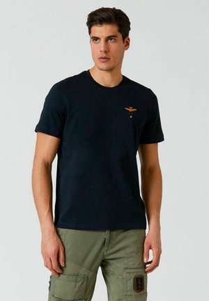 T-shirt in cotone blu navy con maniche corte, collo rotondo e piccolo logo ricamato sul petto. Tessuto morbido, vestibilità classica.