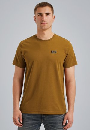 T-shirt di cotone color senape con collo rotondo e maniche corte. Presenta un piccolo etichetta nera sul petto e un design classico aderente.