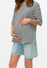 Randig mammatopp i gräddvit och marinblå med avslappnad passform, kombinerad med ljusa denimshorts med uppvikt fåll. Mjukt tyg, avslappnad design.