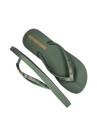 Groene teenslippers met een gestructureerde zool, voorzien van een gestreepte band in tinten groen en metaalaccenten. Lichtgewicht en eenvoudig ontwerp.