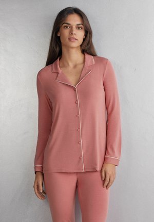 Lange mouwen, roze pyjama set met een knoopsluiting aan de voorkant, witte bies op de kraag en manchetten, een gladde stof en een relaxte pasvorm.