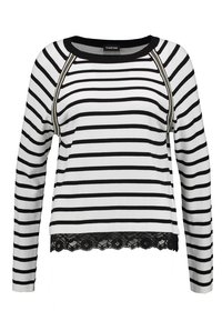 Chemise à manches longues à rayures noires et blanches avec une finition en dentelle à l'ourlet et un col rond. Présente des coutures contrastées sur les coutures d'épaule.