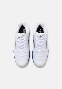 Scarpe athletic bianche con tomaia in rete, design testurizzato, logo nero sulla linguetta e accenti blu sulla suola. Sistema di allacciatura simmetrica.