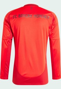 Camisa de manga larga del FC Bayern München en un vibrante color rojo. Presenta un cuello redondo, una tela suave, letras grises en la parte trasera y costuras acentuadas.