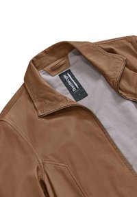 Giacca in pelle tan con una superficie liscia, chiusura con zip e collo classico. L'interno presenta una fodera in tessuto leggero e un'etichetta del marchio.