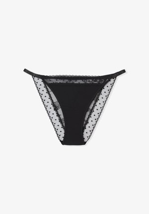 Schwarzes String-Unterwäsche mit Spitzenbesatz und Netzseiten mit Polka-Dot-Mustern, glattem Stoff und verstellbaren Trägern.