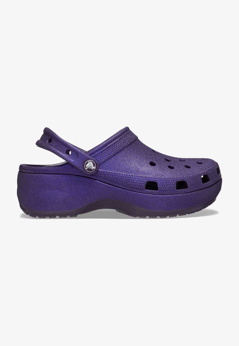 Sabot plateforme violet avec trous de ventilation, bride arrière ajustable et semelle texturée antidérapante, vu de côté.