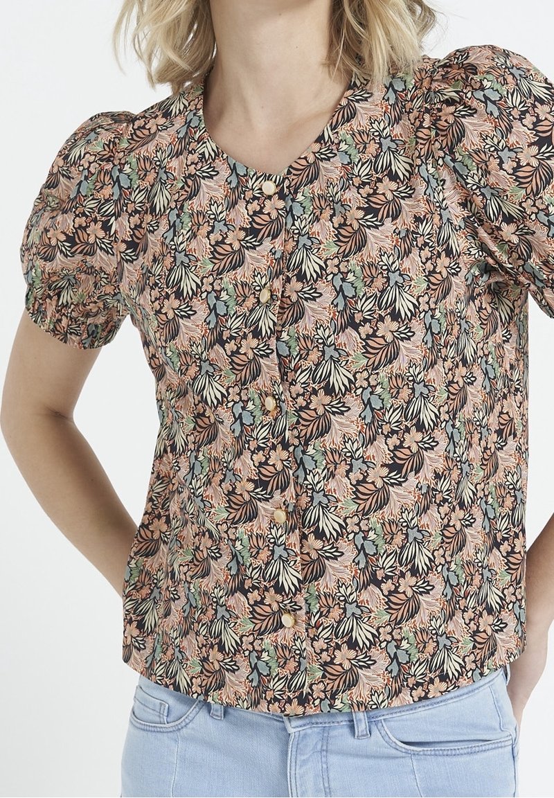 Floral-patterned blouse with short puff sleeves, featuring buttons and a black background. Colors include peach, green, and cream.