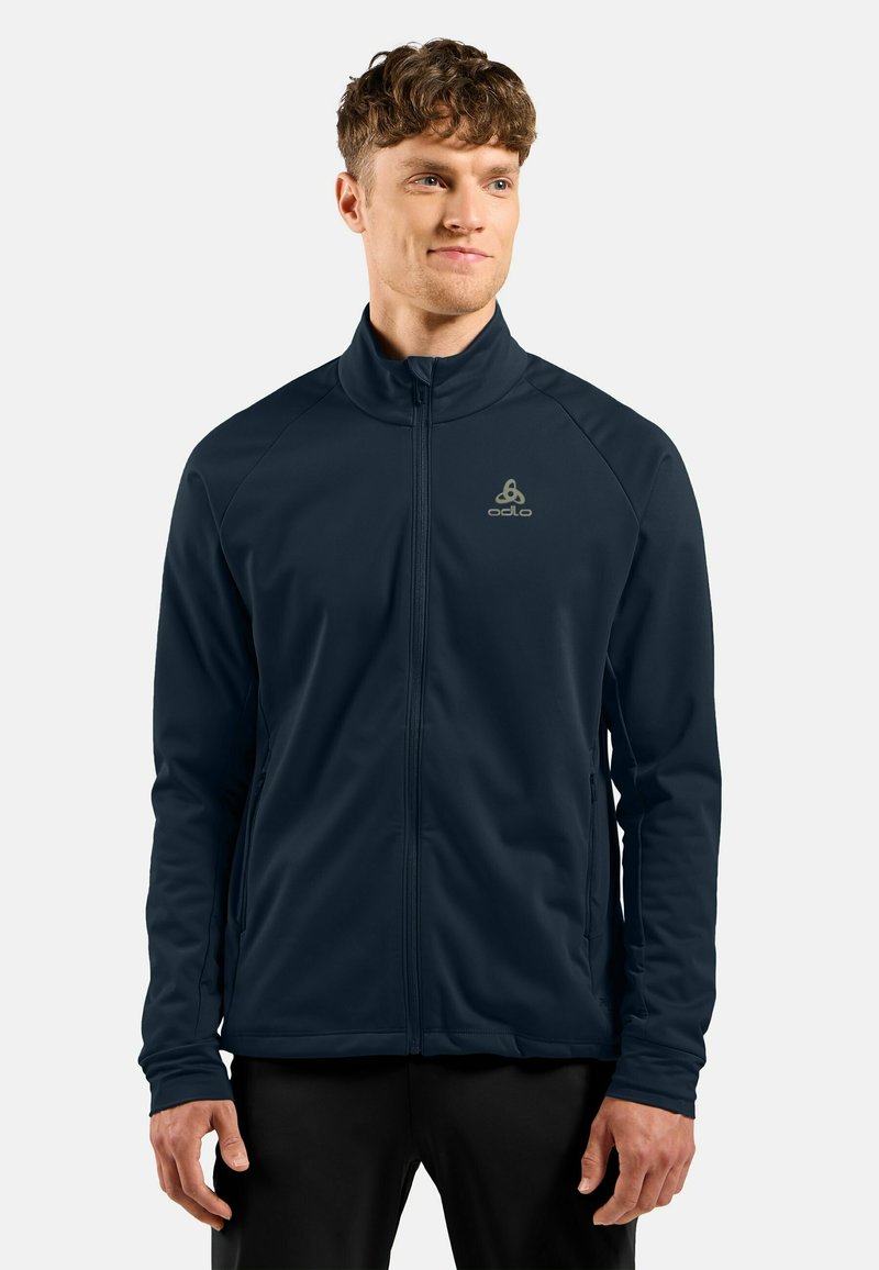 Mannelijke marineblauwe sportjack, gladde textuur, volledige rits, hoge kraag, logo op de borst, lange mouwen, zijzakken en een slim-fit ontwerp.