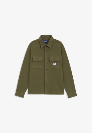 Olivgrünes Cordhemd mit Button-Down-Kragen, zwei Brusttaschen und schwarzen Knöpfen, mit einem kleinen Markenetikett.